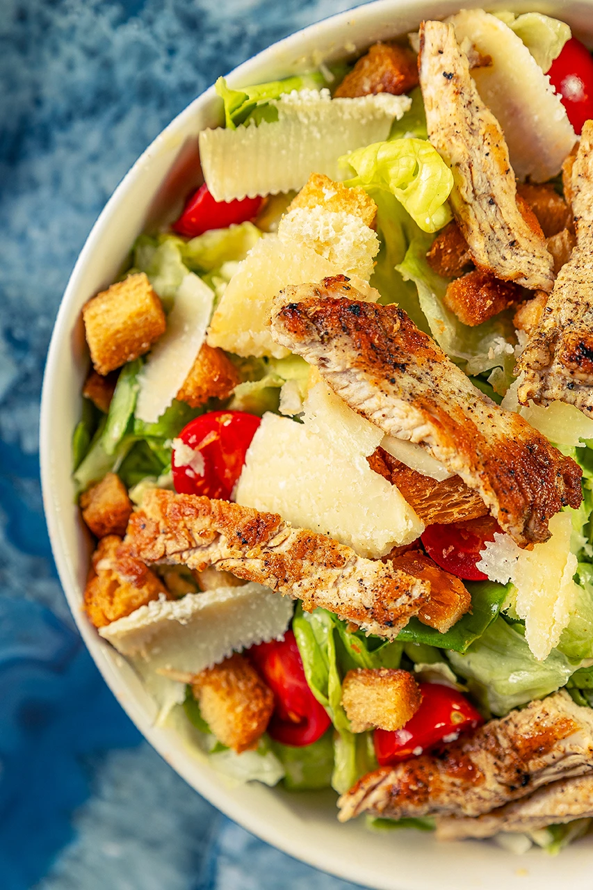 Salade César au poulet grillé, copeaux de parmesan, croûtons et tomates cerises